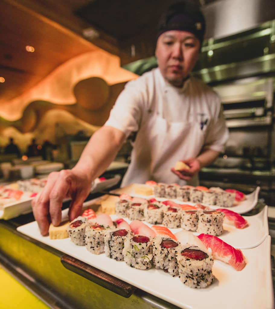 Sushi chef arranging maki rolls